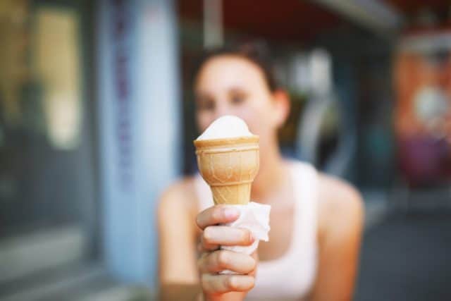 Ice cream in woman's hand close up, selective focus