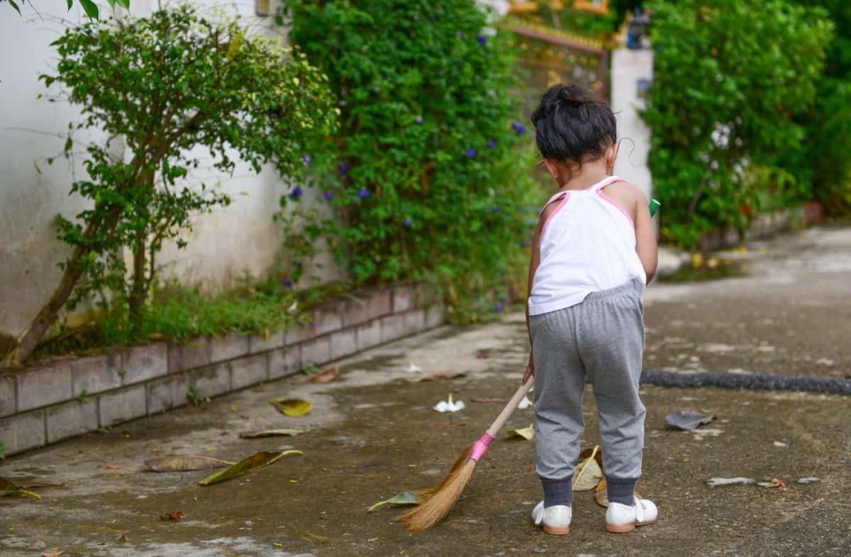 Healthy Asian child is cleaning the floor.Healthy Asian child is cleaning the road.