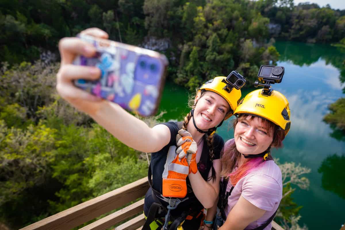 Kids taking a selfie as they zipline. 