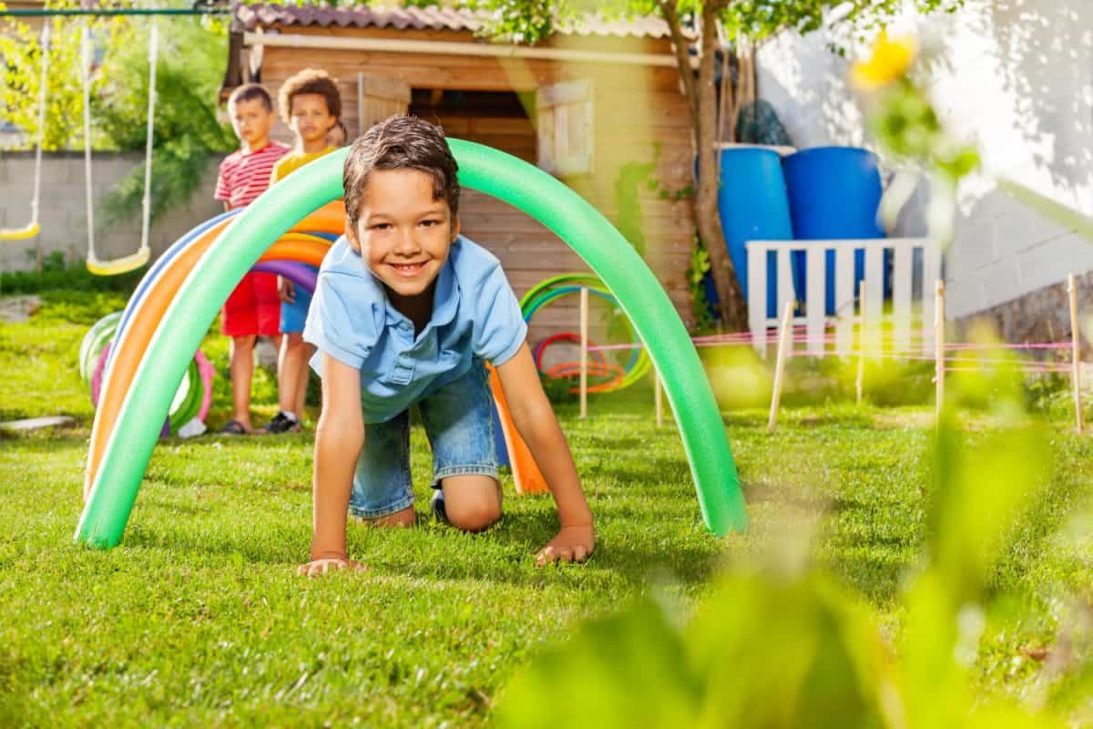 Kids crawl under barriers in a competitive game