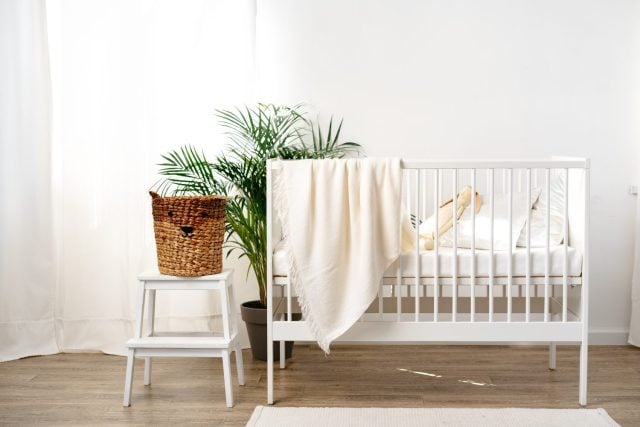 Muslin baby blanket hanging on child's bed in nursing room